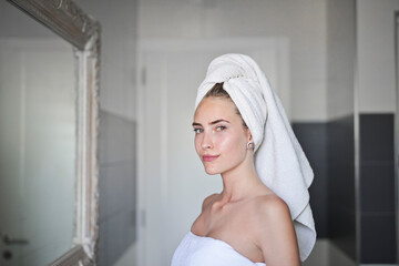 young woman with towel on head in bathroom