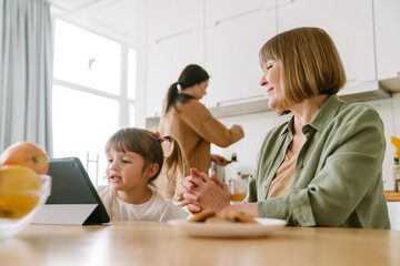 White girl using tablet computer while spending time with her family