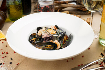 seafood mussels shrimp and baby octopus in a white plate
