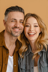 White happy couple wearing shirts smiling and looking at camera