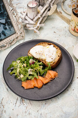 breakfast fresh salad with salmon and bruschetta with spread on a white background
