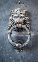 Old metal door handle in the form of a lion head. Door knocker closeup. Venice, Italy