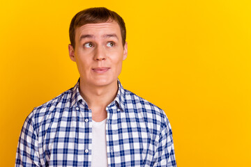 Photo of young guy happy dream think look empty space isolated over vibrant yellow color background