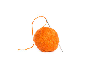 ball of orange wool yarn and a needle with a stretched thread on a white background