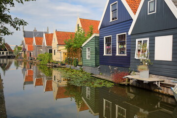 Colorful and historic house facades in De Rijp, Alkmaar, North Holland, Netherlands, reflected on a canal. De Rijp is known for its rijksmonuments