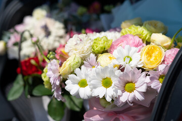 Bouquets of beautiful bright multi-colored flowers in the trunk of a car, a gift for a wedding, for a birthday