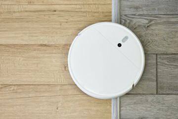 Robot vacuum cleaner drives on different surface. Overcoming doorstep with robot vacuum cleaner....