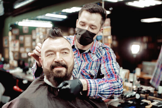 Beard dyeing in a barbershop. a young master applies paint