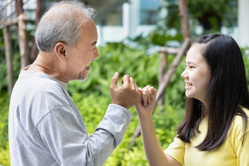 Teen girl having pinky promise with old grandfather or late-married senior father - obrazy, fototapety, plakaty