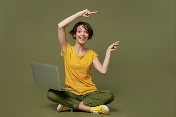 Full body young happy woman she 20s wear yellow t-shirt sitting hold use work on laptop pc computer...