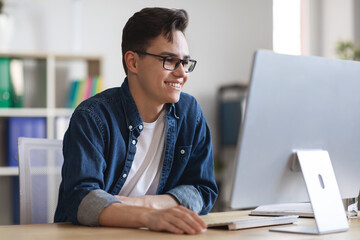 Portrait Of Smiling Millennial Businessman Working On Computer In Office