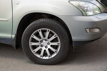 Obraz na płótnie Canvas Close-up of a car wheel with a disc and a tire.