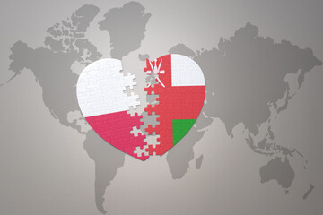 puzzle heart with the national flag of oman and poland on a world map background.Concept.