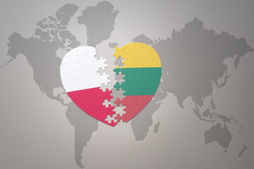 puzzle heart with the national flag of lithuania and poland on a world map background.Concept.