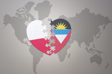 puzzle heart with the national flag of antigua and barbuda and poland on a world map background.Concept.