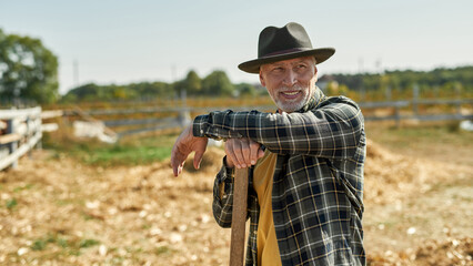 Fototapeta premium Farmer with agricultural tool during work on farm