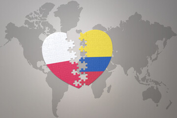 puzzle heart with the national flag of colombia and poland on a world map background.Concept.