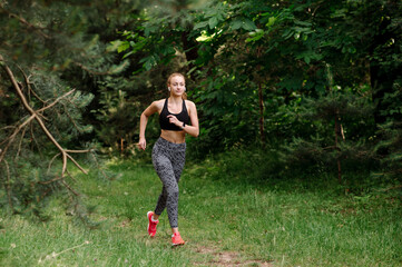 Sporty woman is jogging outdoors in the park