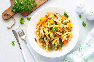 Vegan pasta fusilli with vegetables, zucchini, paprika and grean beans. Meatless vegetarian menu. Top view on white.