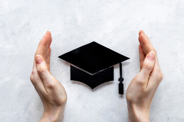 Students hands with graduation hat or academic cap paper cut