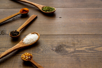 Powdered spices and herbs in wooden spoons. Colorful cooking background