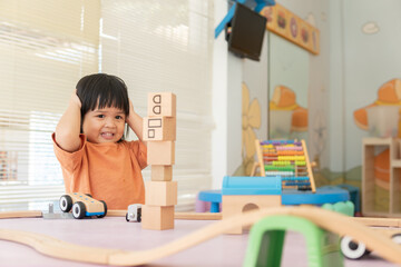 Kids intend learn from play with colorful wooden toy on table desk at home. Preschool young girl concentrating with educational block in recess term back to school Children at home or daycare child. - obrazy, fototapety, plakaty