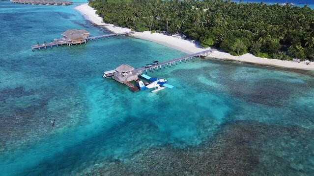 Drone top down view of a Seaplane. Tropical atoll island in Maldives with coral reef and turquoise sea water. Touristic vacation holidays travel destination. Scenic seascape. Vakkaru, Maldives.