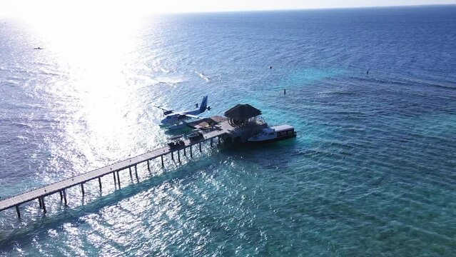 AERIAL: Tourists get on board to depart from the Maldivian island. Hotel employees escort vacationers. Seaplane transporting passengers from small islands to Male Airport.