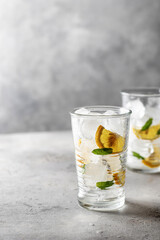 Iced cold lemon mint summer cocktail on gray background with text space on the left