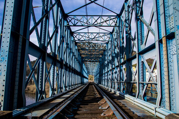 old blue metal bridge and the train track in the town of Os Peares. Ribeira Sacra. Galicia