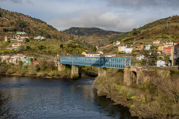 Panoramic view of the town of Os Peares, its blue train bridge and the Miño river. Ourense. Galicia. Ribeira Sacra