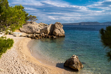Obraz premium Beautiful view of empty Brela rocky beach. Makarska Riviera in Dalmatia region of Croatia. Adriatic coastline. Island Brac in the background..