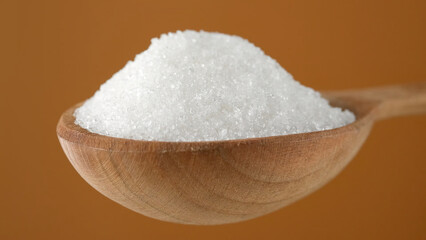 White powder sugar in wooden spoon. 