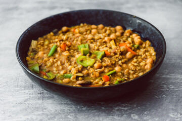 healthy plant-based food, vegan barley and lentil dahl with bell peppers,