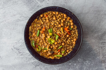 healthy plant-based food, vegan barley and lentil dahl with bell peppers,