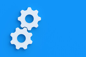 Two gears on blue background. Engineering technology. Mechanism development. Industrial progress. Idea concept. Business cooperation. Teamwork and communication. Top view. Copy space. 3d render