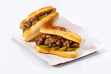 Street food sandwiches with meat, pickled cucumbers on a white plate. White background. Side view.