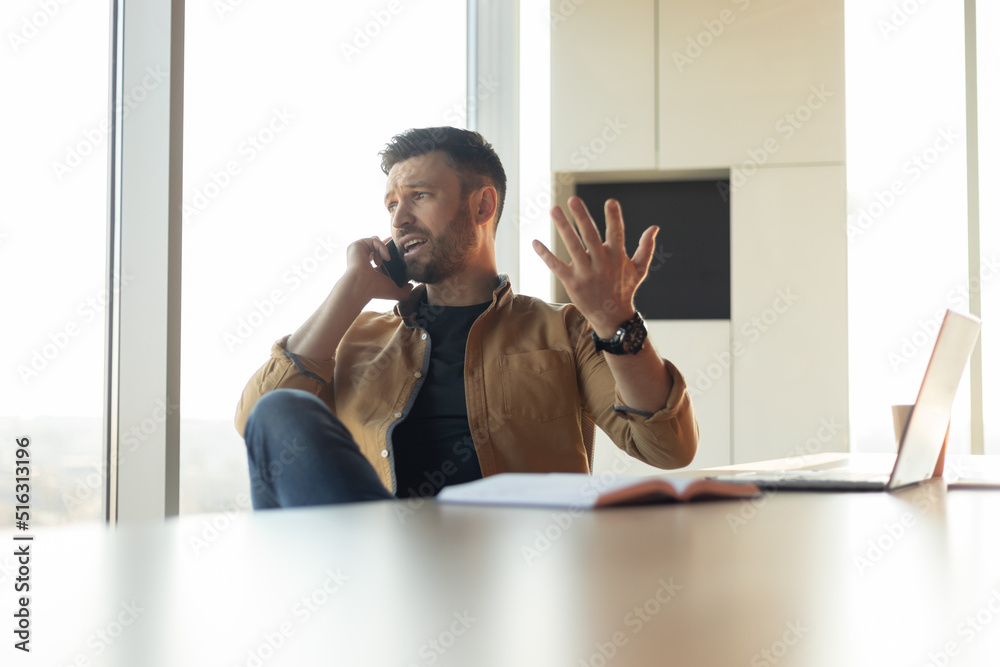 Aufkleber discontented businessman talking on cellphone solving business problems in office