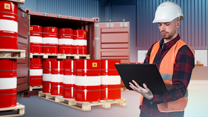 Fuel transportation. Man with laptop in front of shipping container. Barrels of oil on pallets. Red...
