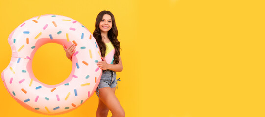 happy beach teen girl with donut inflatable ring for pool party fun on summer vacation, summertime. Banner of summer child girl in swimsuit, studio poster header with copy space.