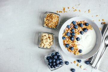 Obraz na płótnie Canvas Yogurt with muesli and berries on a gray background.