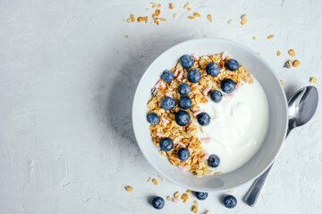 Yogurt with muesli and berries on a gray background.