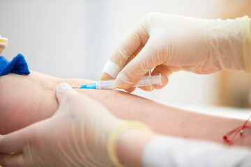 The doctor makes an injection into the patient's vein.