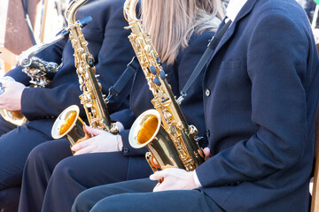 Saxophones in the hands of musicians.