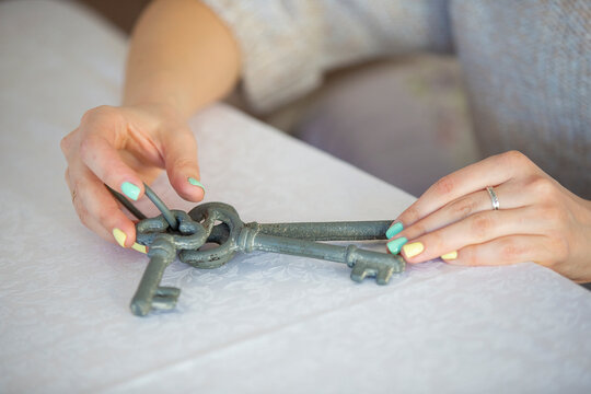 Woman's hands hold vintage keys. Pick up the key to the heart.