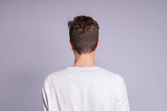 Back view of young man over gray background..