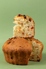 Classic cottage cheese pie with raisins.Cupcake with a cut piece on a green background.