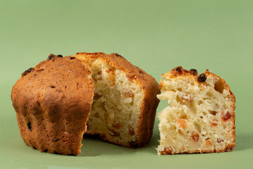 Classic cottage cheese pie with raisins.Cupcake with a cut piece on a green background.