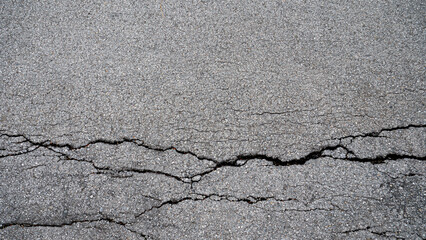 Obraz premium Cracks or splits on the road surface. Damaged asphalt roads