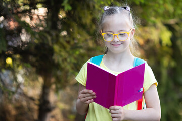 Fototapeta premium A girl with Down syndrome looks at the timetable
